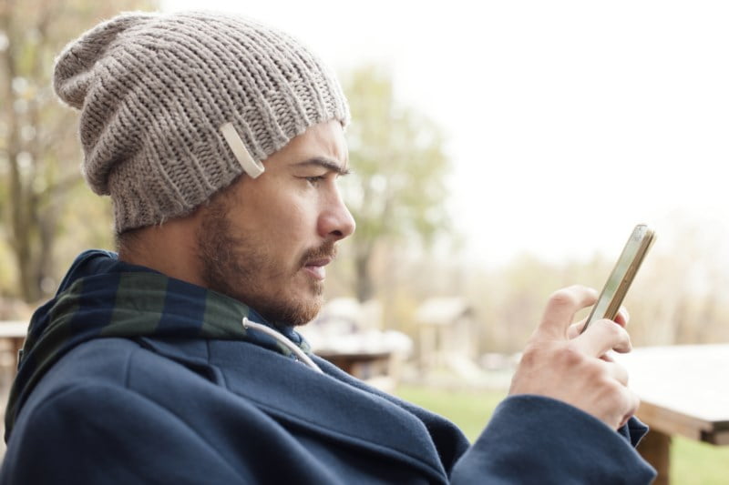 Mann som spiller på telefon