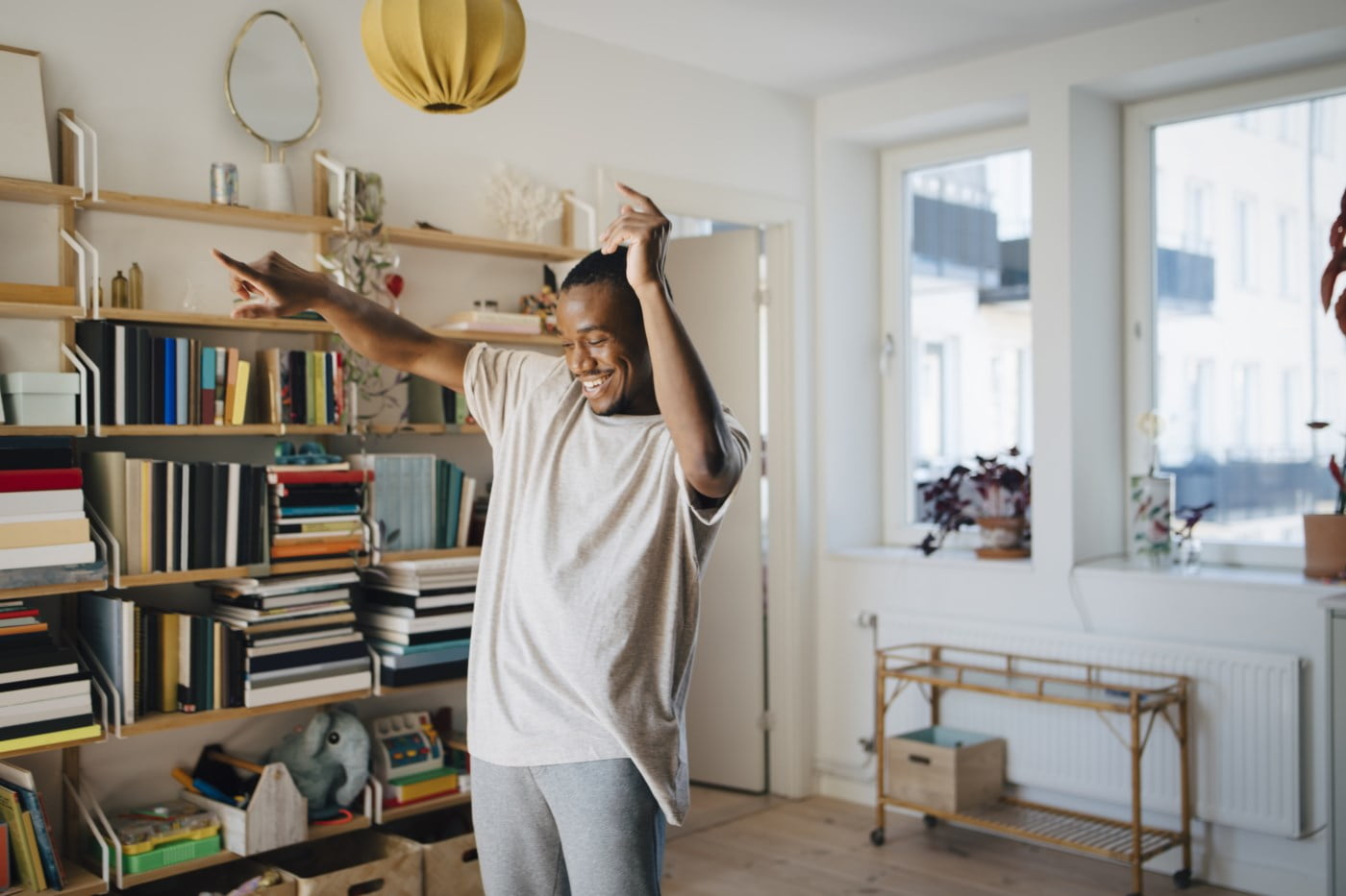 Glad mann som danser i stuen - råd for å komme inn på boligmarkedet